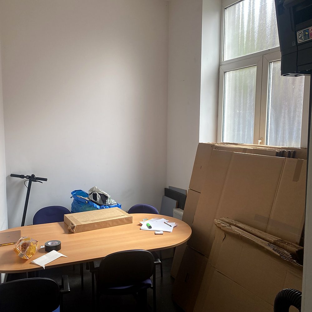 Salle de réunion avec table, chaises et cartons avant le débarras
